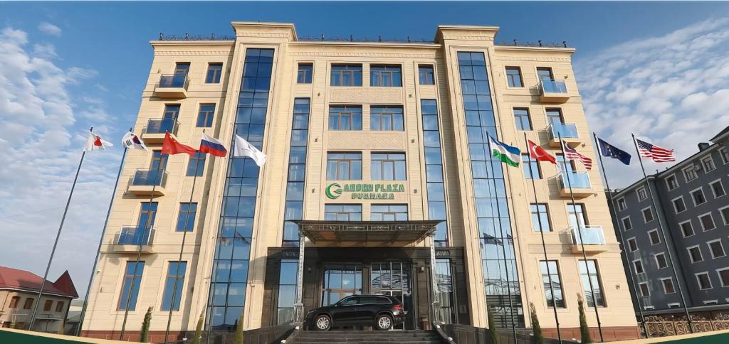 un bâtiment avec une voiture garée devant lui dans l'établissement Garden Plaza Bukhara, à Boukhara