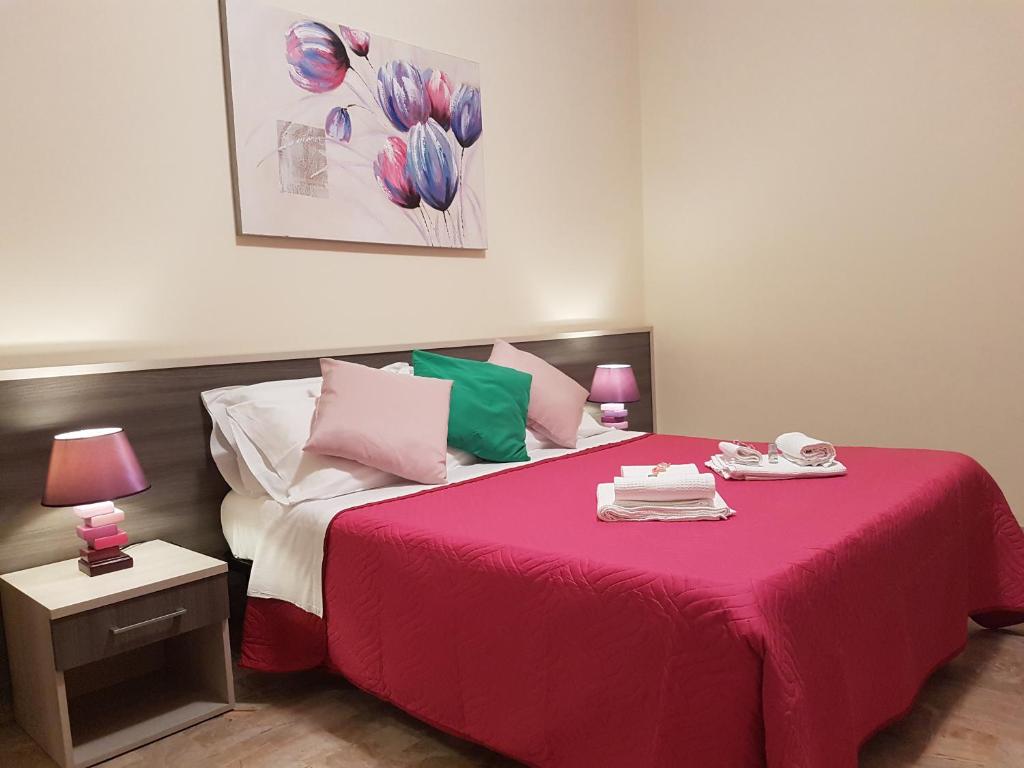 a bedroom with a large bed with a red blanket at B&B Monté in Montesilvano