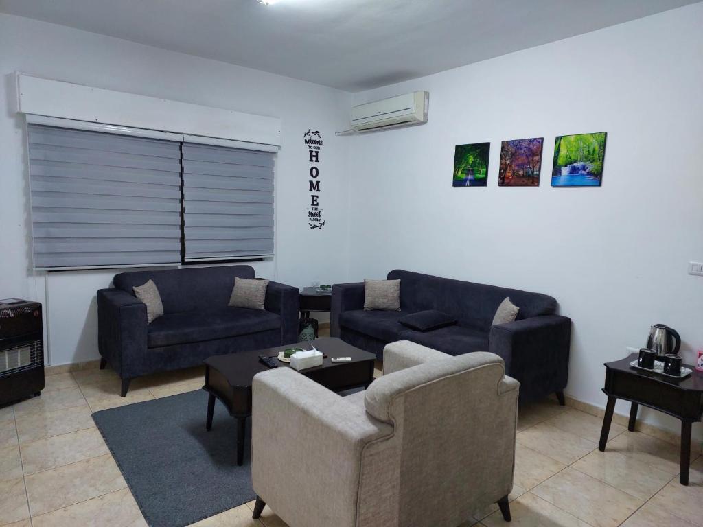 ein Wohnzimmer mit Sofas, einem Sofa und einem Tisch in der Unterkunft Cozy Home in Amman