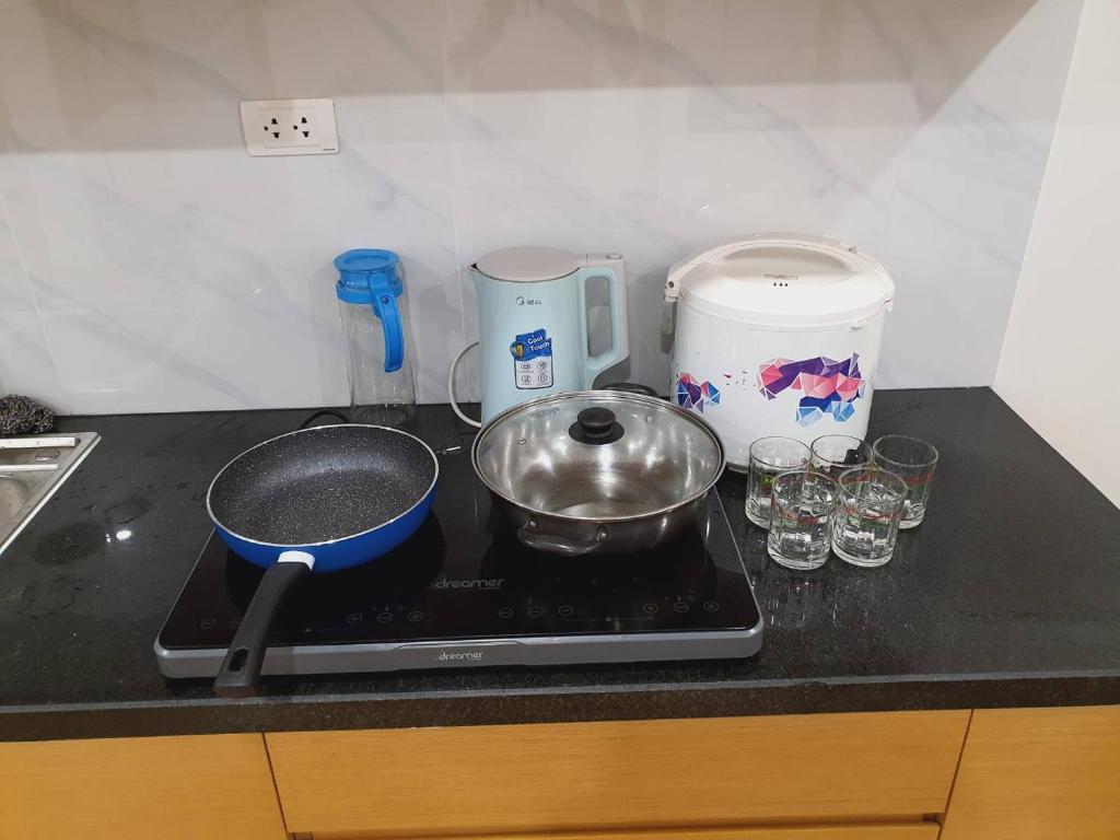 un bancone della cucina con piano cottura, padella e bicchieri di TMS Quy Nhơn-Chuee Homestay a Quy Nhon