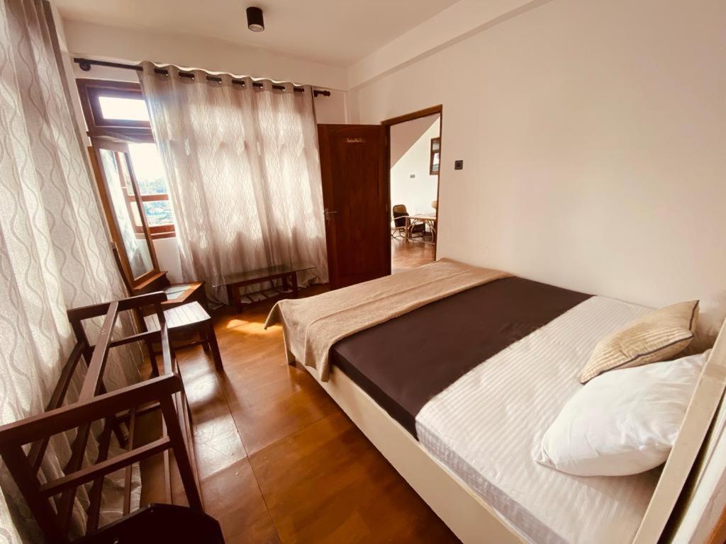 1 dormitorio con cama, mesa y espejo en Villa castle en Nuwara Eliya