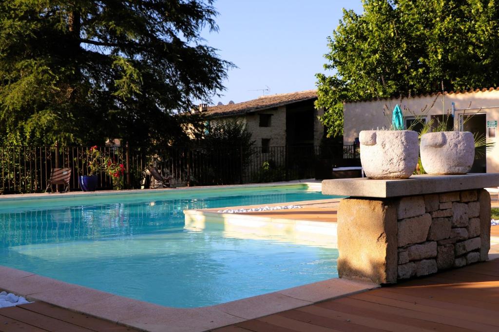 een zwembad met blauw water in een tuin bij Les Demeures du Clos in Niozelles