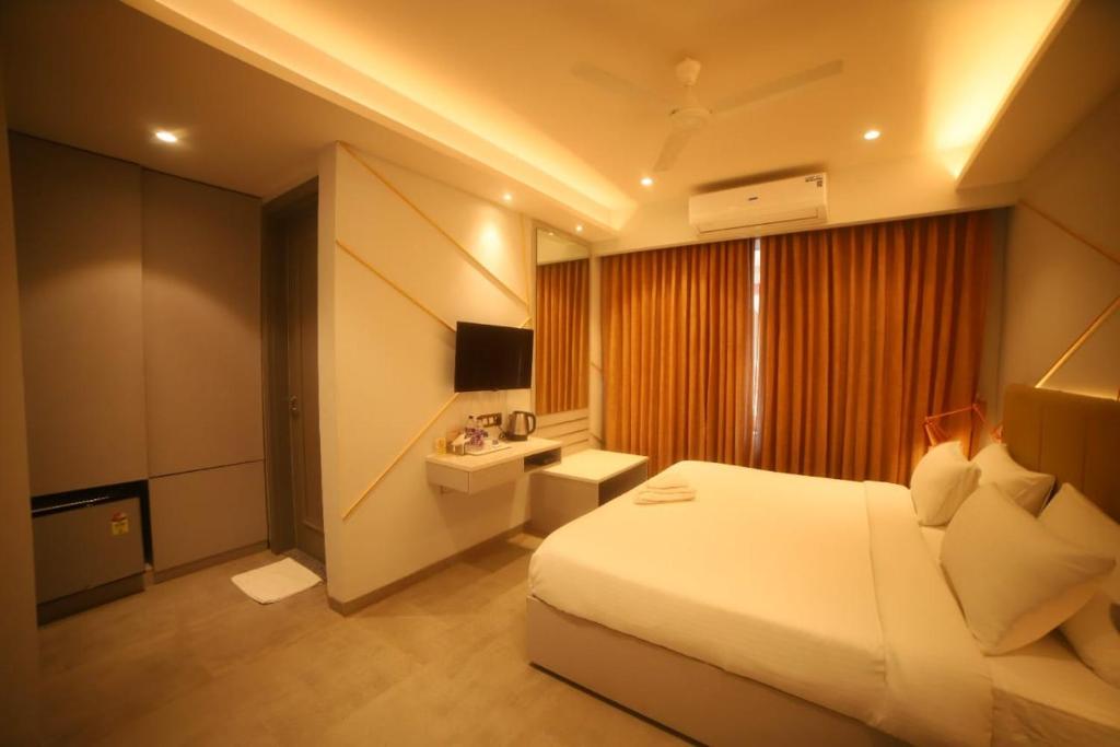 a hotel room with a bed and a television at Waltair Abode in Visakhapatnam