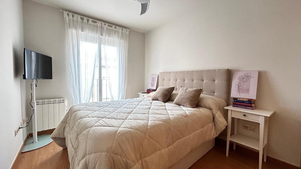 - une chambre avec un grand lit et une fenêtre dans l'établissement El Pajar del Toro, à San Cristóbal de Segovia