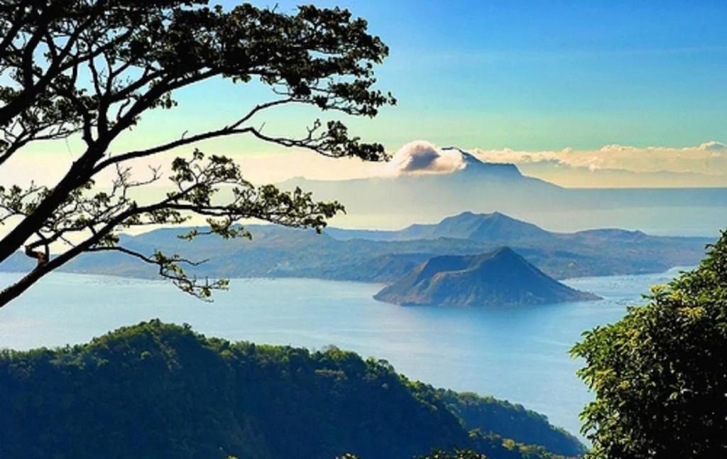 a view of a large body of water with a mountain at Blowing In The Wind in Tagaytay