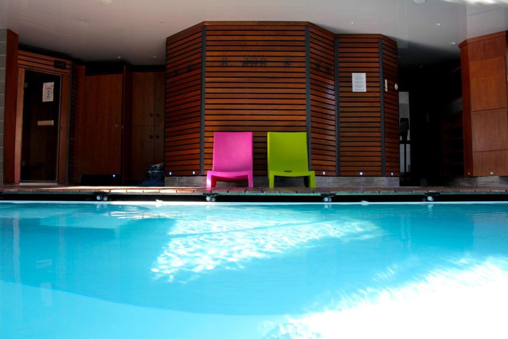 two chairs sitting next to a swimming pool at Domaine du Clos Fleuri - Spa in Honfleur