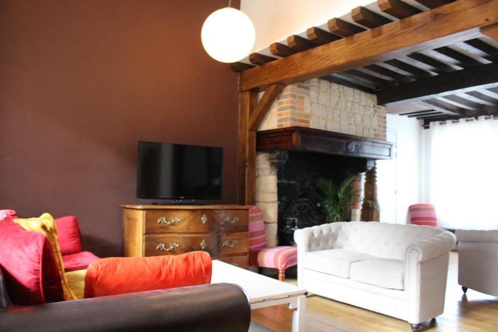 a living room with a couch and a fireplace at Domaine du Clos Fleuri - Spa in Honfleur