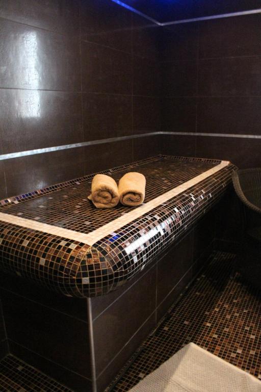 two rolls of towels sitting on a rack in a bath tub at Domaine du Clos Fleuri - Spa in Honfleur