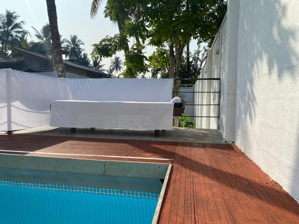 a swimming pool with a bench on the side of a building at Island Star POOL & SPA in Galle