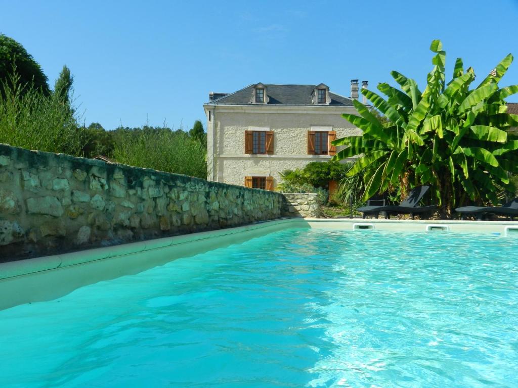 a swimming pool in front of a house at La Maison Saint-Martin in Agonac