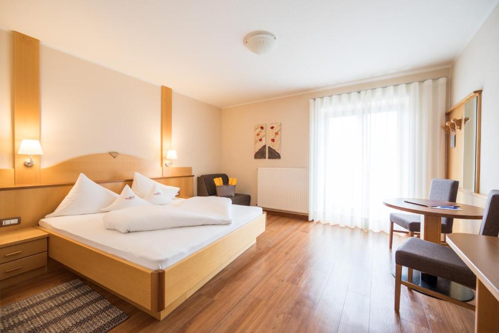 a hotel room with a bed and a desk at Waidmannhof in Merano