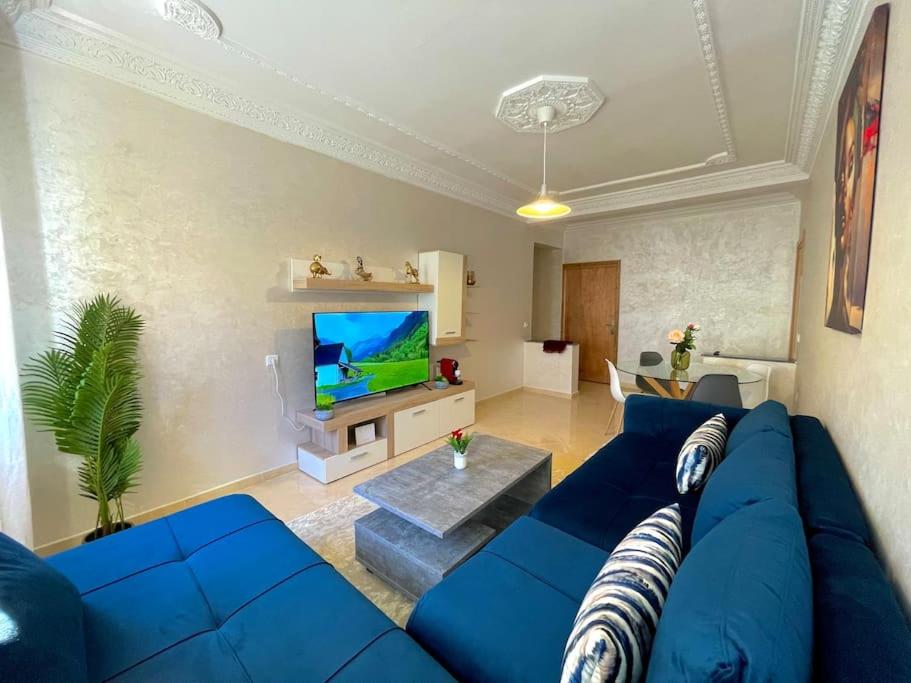 salon z niebieską kanapą i telewizorem w obiekcie F4 Appartement entièrement neuf au cœur de Témara w mieście Temara