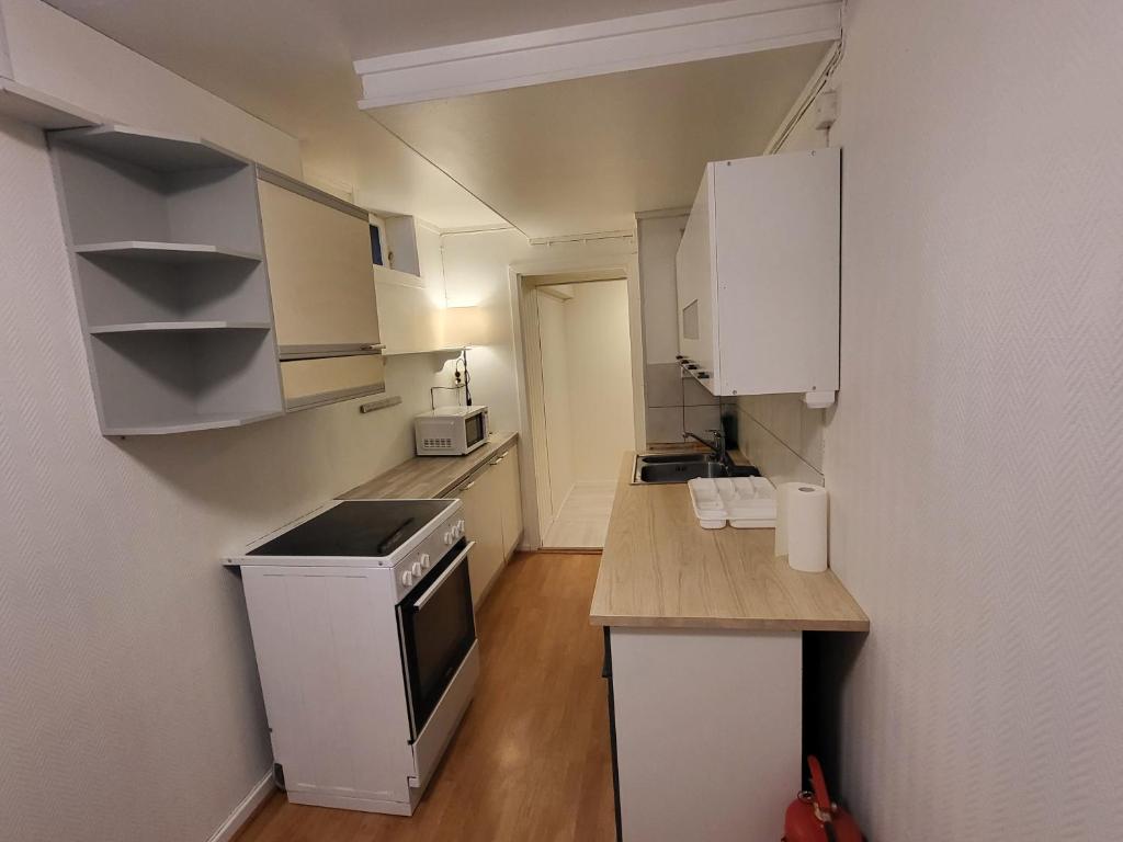 a small kitchen with white cabinets and a counter top at 6 Bedrooms, 14 Guest Apartment in Kjeller Lillestrøm - Good proximity to OSLOMET and Lillestrøm Train Station in Lillestrøm