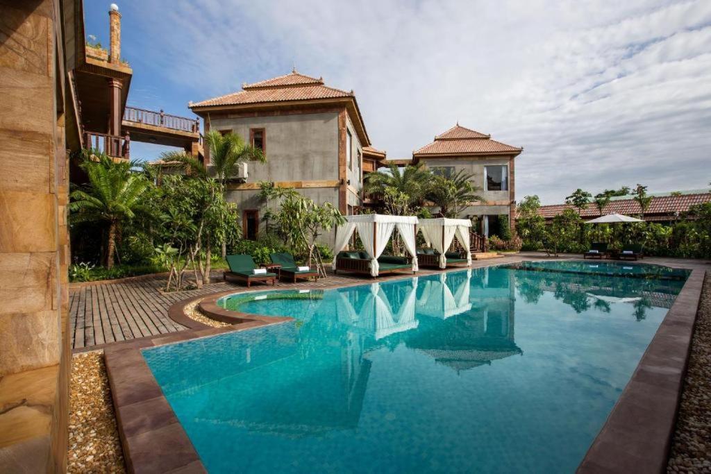 a swimming pool in front of a house at Model Temple Residence in Phumi Ta Phul