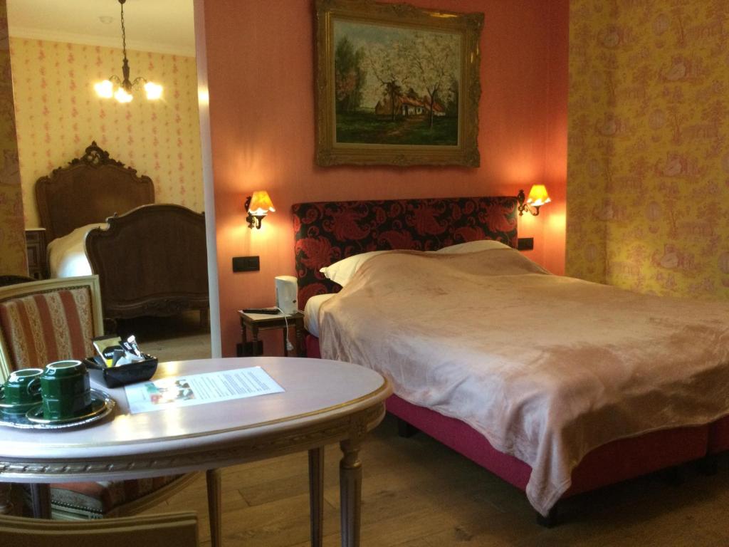 una camera d'albergo con letto, tavolo e sidro. di L'auberge a Baronville