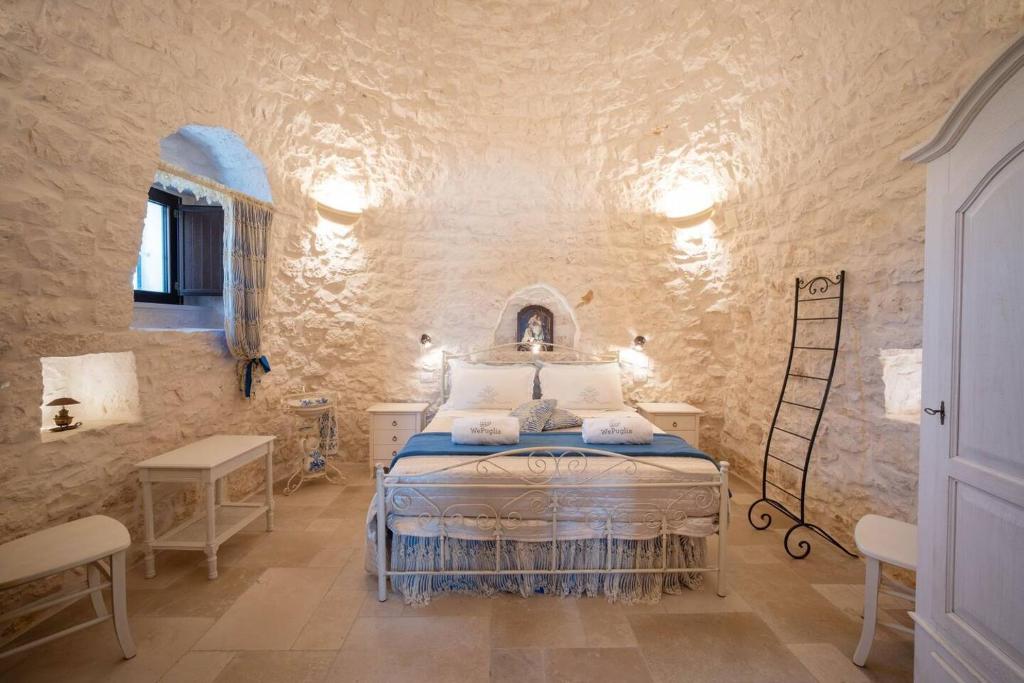 een slaapkamer met een bed in een stenen muur bij Valle D'Itria Trulli e Alcova Mikael in Cisternino