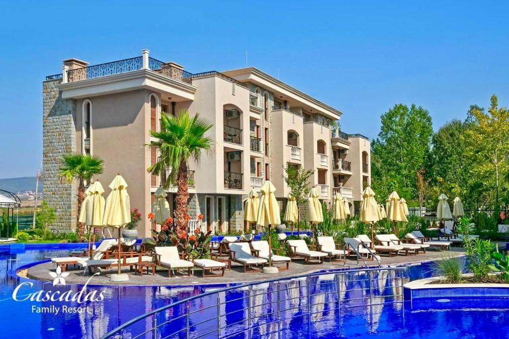 a hotel with chairs and umbrellas next to a pool at Апартамент Каскадас В54 in Sunny Beach