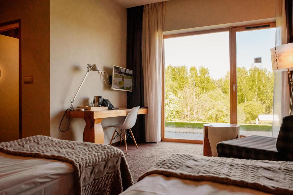 a hotel room with a desk and a window at Głęboczek Vine Resort& Spa in Wielki Głęboczek