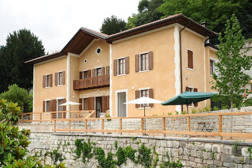 a large building with tables and umbrellas in front of it at La Villa degli Orti in Borgo