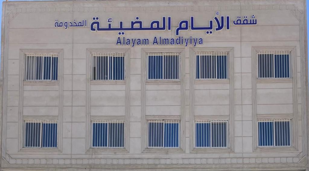 a white building with a sign on top of it at شقق الايام المضيئة المخدومة in Najran