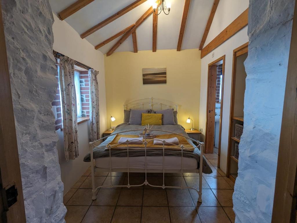 a bedroom with a bed in a room with a stone wall at Immaculate 1-Bed Cottage in Bideford in Bideford