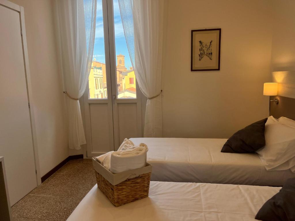 a hotel room with two beds and a window at LaMì Room & Apartment in Castel San Pietro Terme