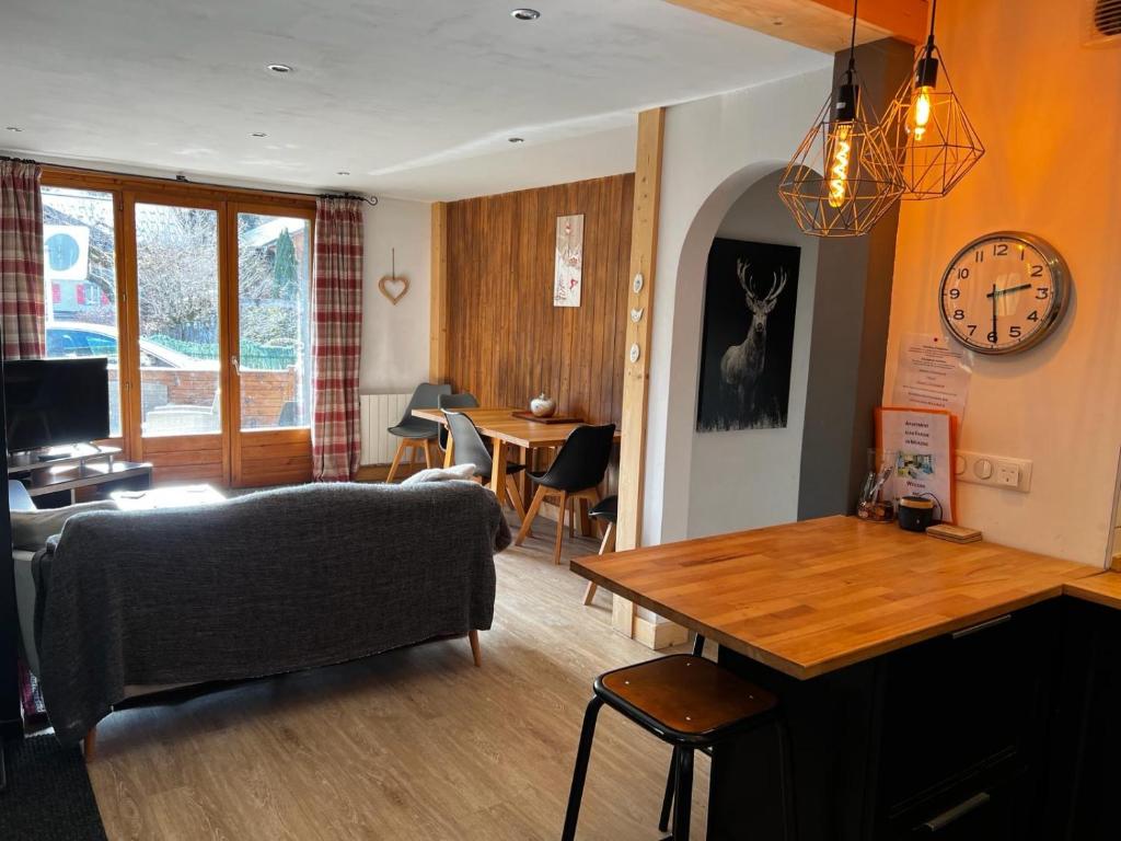 a living room with a couch and a clock on the wall at Lovely 2 Bed Apartment in Morzine with garden in Morzine