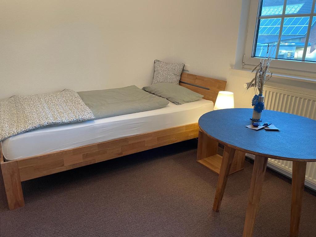 a bed and a table in a room at Landhaus am Loh in Wesel