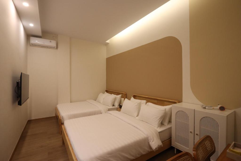 a hotel room with two beds and a tv at Casabella 101 A2 Grand Batam Penuin Wet Market in Nagoya