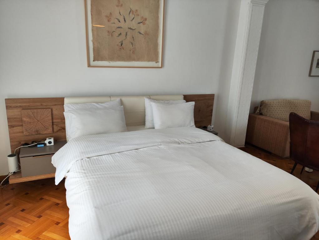 - une chambre avec un grand lit et des draps blancs dans l'établissement Ulysses Apartments Acropolis, à Athènes