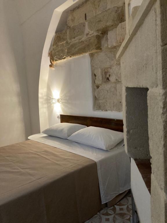 Bett in einem Zimmer mit Ziegelwand in der Unterkunft B&B Antica Dimora dell'Angelo in Nardò