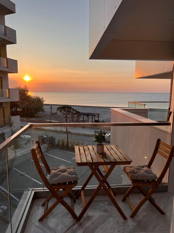 a table and chairs on a balcony with the sunset at DAMAR Infinity Beach and Pool Mamaia- private parking in Mamaia Sat/Năvodari