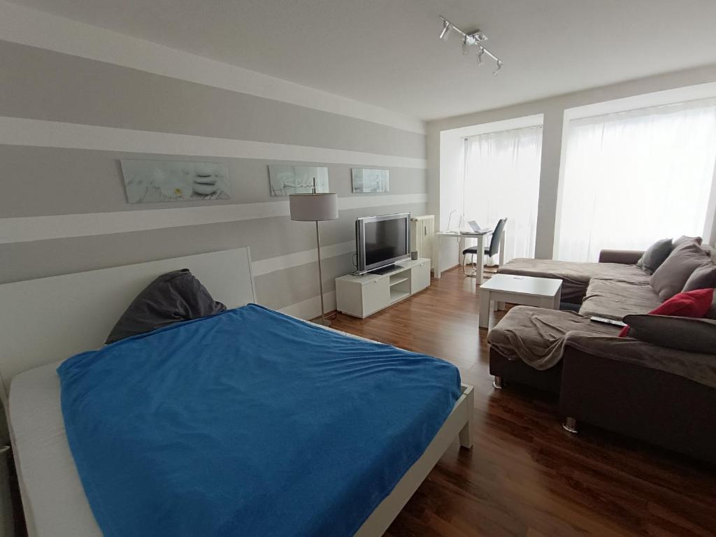 a living room with a blue bed and a couch at Huge Private Room in Best Location in Düsseldorf