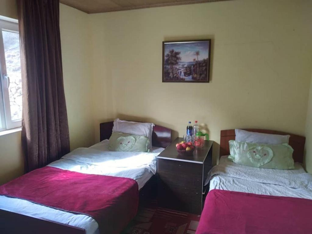 two beds in a room with pink and white sheets at ISKANDARKUL guest house in Kanchoch