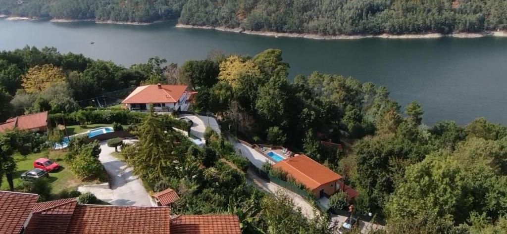 an aerial view of a house next to a lake at Casa Encosta do Rio-ferias no Gerês in Vieira do Minho
