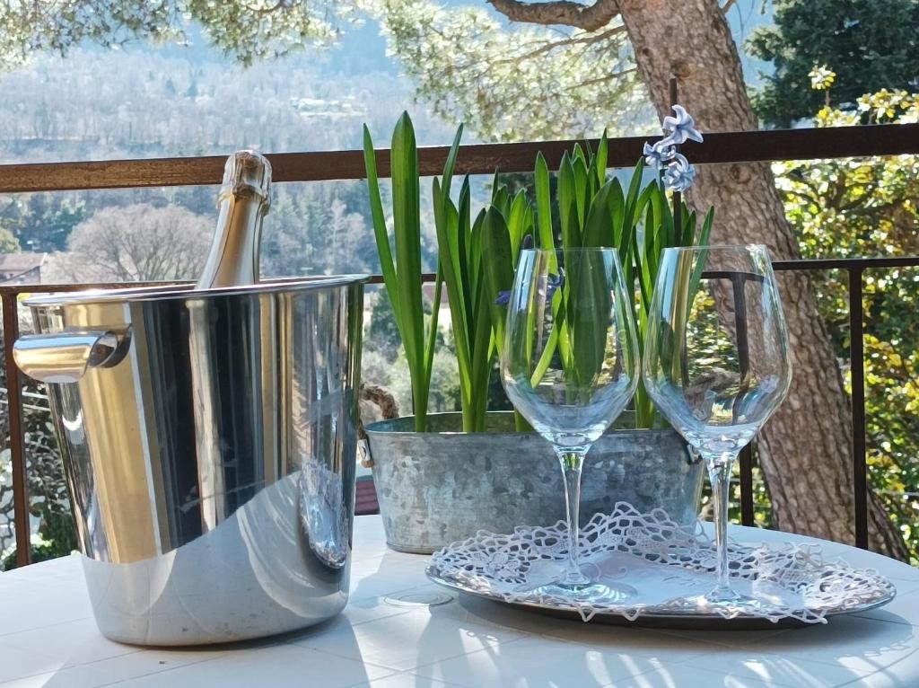 a table with two wine glasses and a bucket at Bed and Breakfast da Pio in Castelveccana