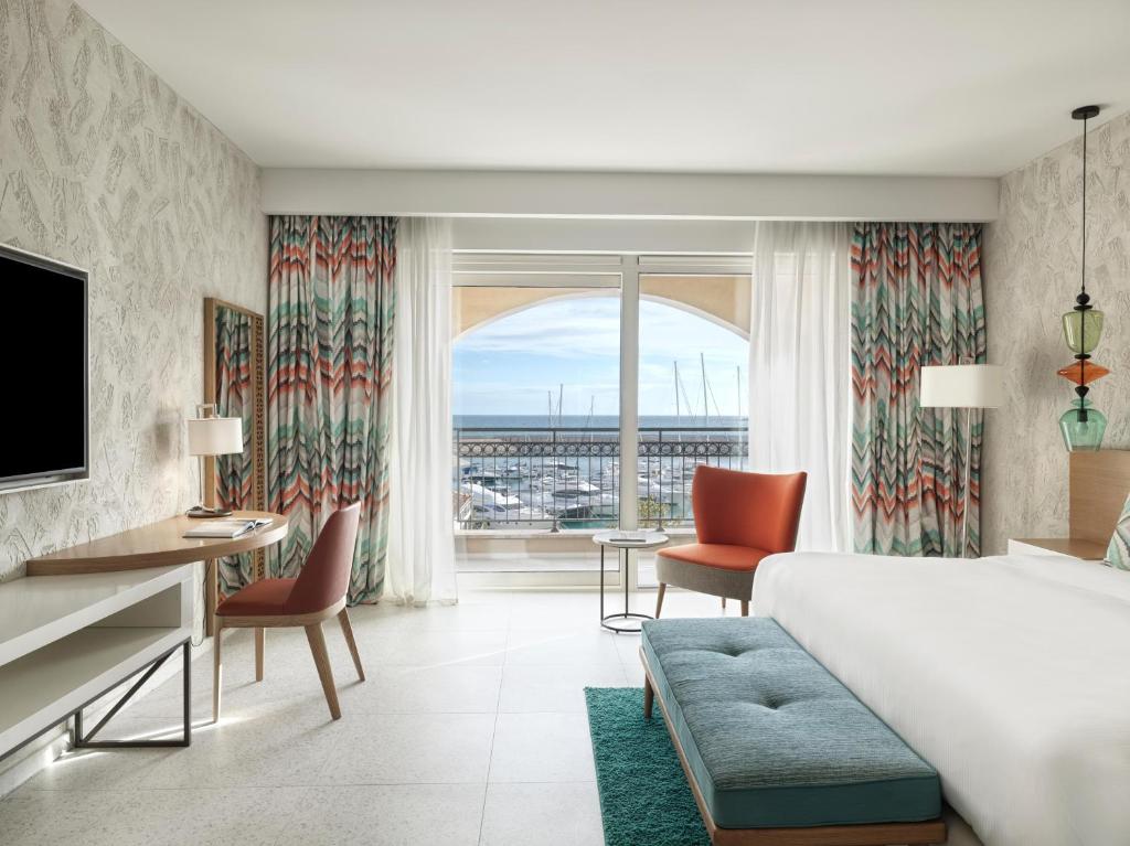 a hotel room with a bed and a desk and chairs at The Chedi Luštica Bay in Tivat