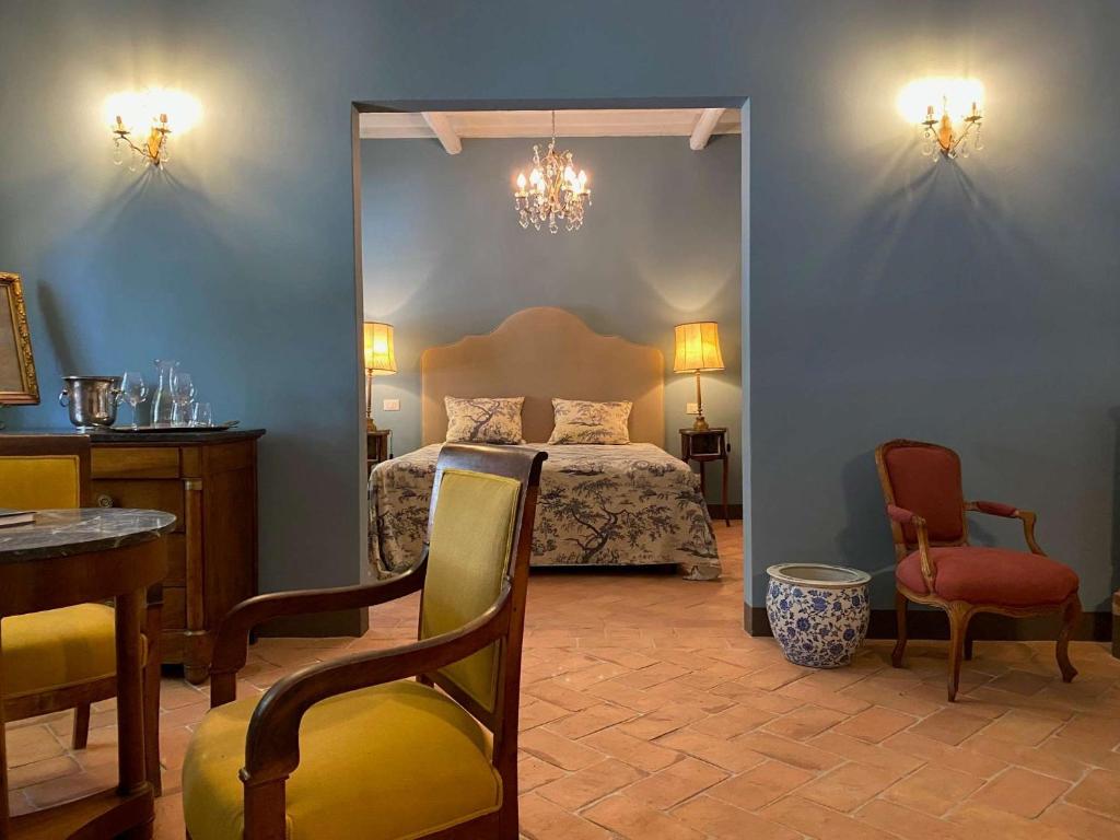 Schlafzimmer mit einem Bett, einem Tisch und Stühlen in der Unterkunft Villa Cosmiana suites in Peccioli