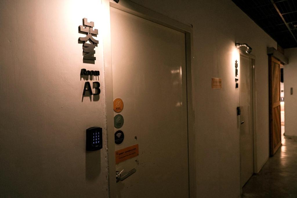 a hallway with a wall with a exit sign on it at Meeting Mates Hostel in Taipei