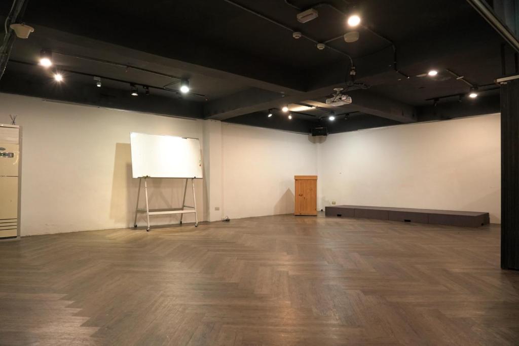 a large room with a white wall and a white board at Meeting Mates Hostel in Taipei