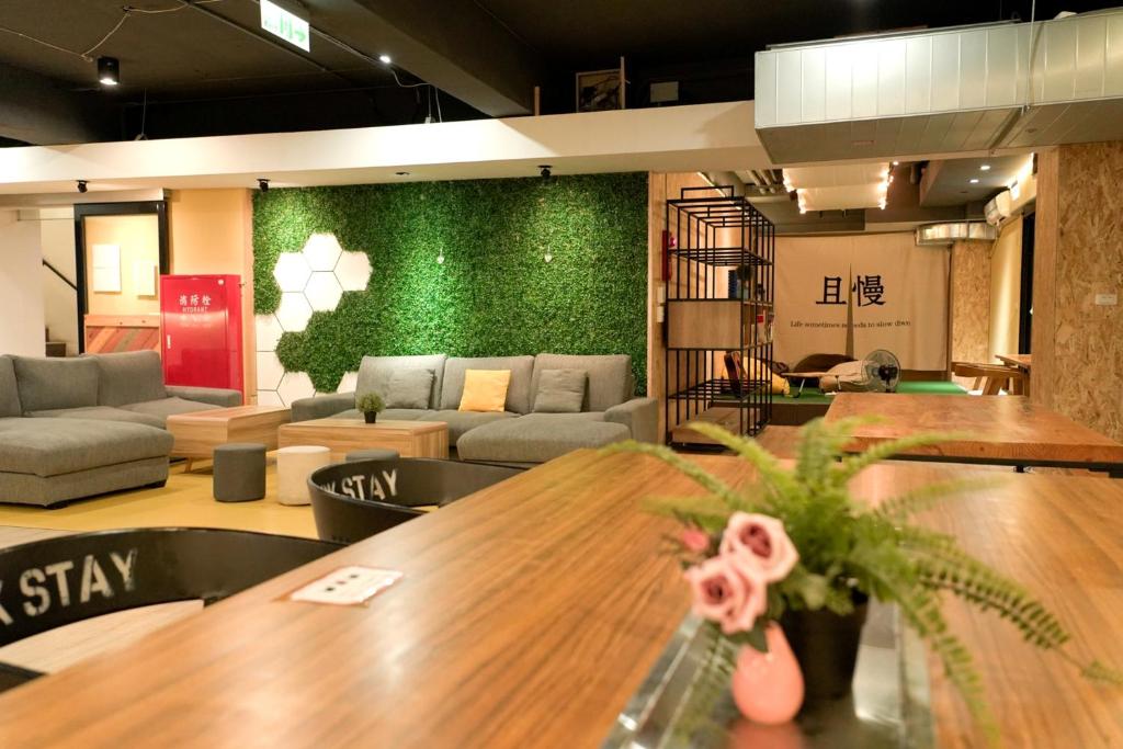 a living room with a table and a green wall at Meeting Mates Hostel in Taipei