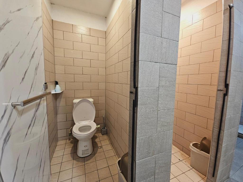 a bathroom with a toilet and a shower stall at Meeting Mates Hostel in Taipei