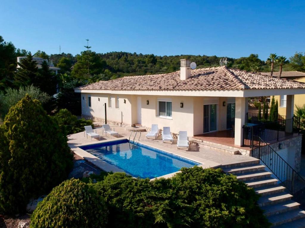 uma casa com uma piscina em frente em Villa Victoria em L'Ampolla