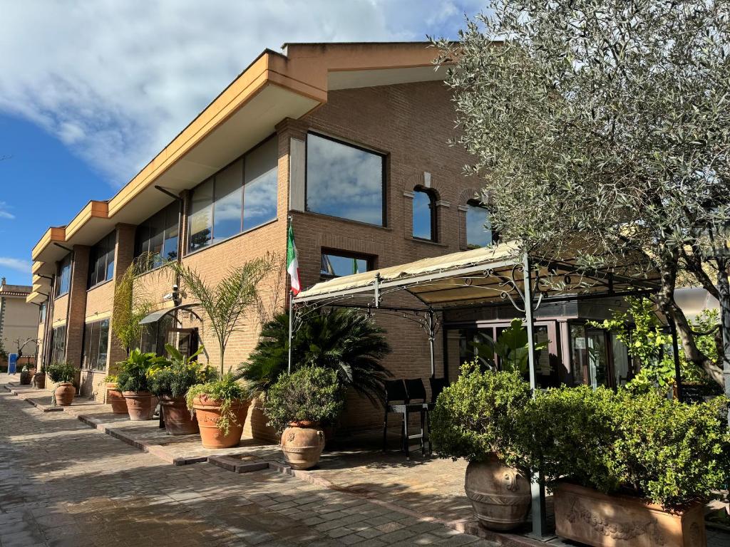 a building with potted plants in front of it at Euro House Inn Airport in Fiumicino