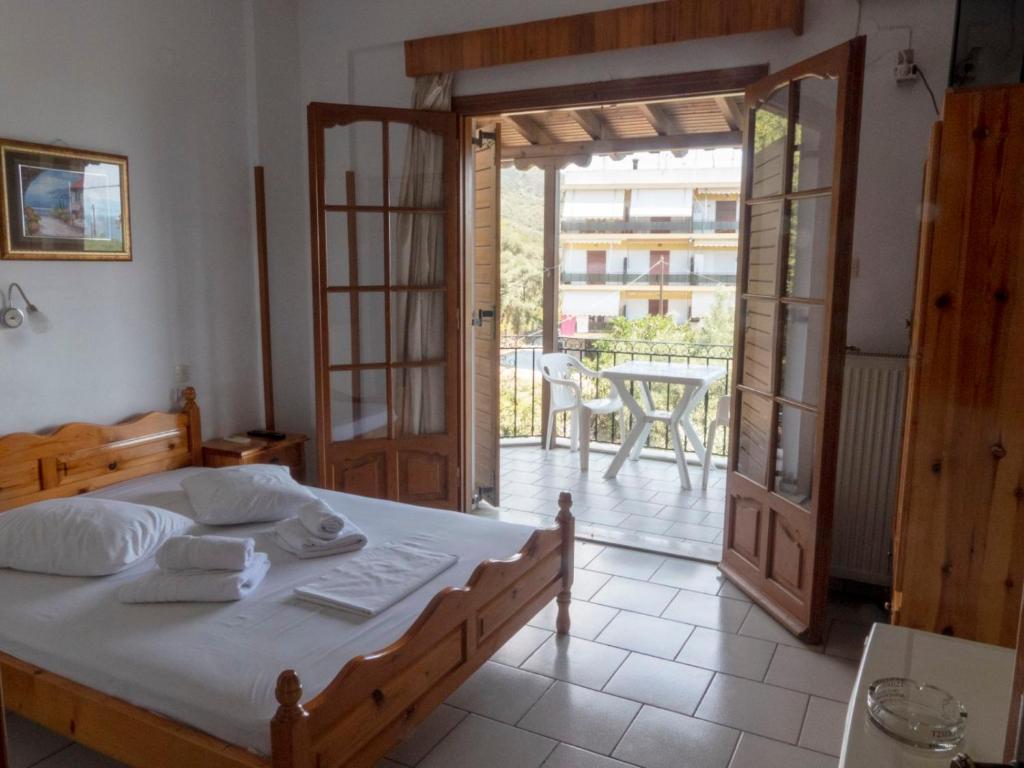 a bedroom with a bed and a balcony with a table at Anastasia in Áno Lekhónia