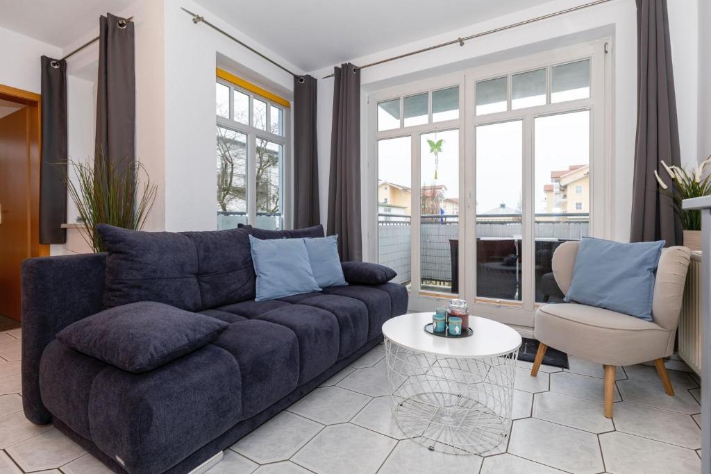 sala de estar con sofá azul y mesa en Brücken-Butze Whg 12 Villa Strandburg, en Kühlungsborn