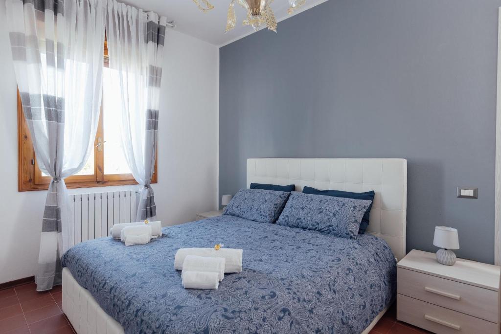 a bedroom with a blue bed and a window at APPARTAMENTO ACACIA in Imola