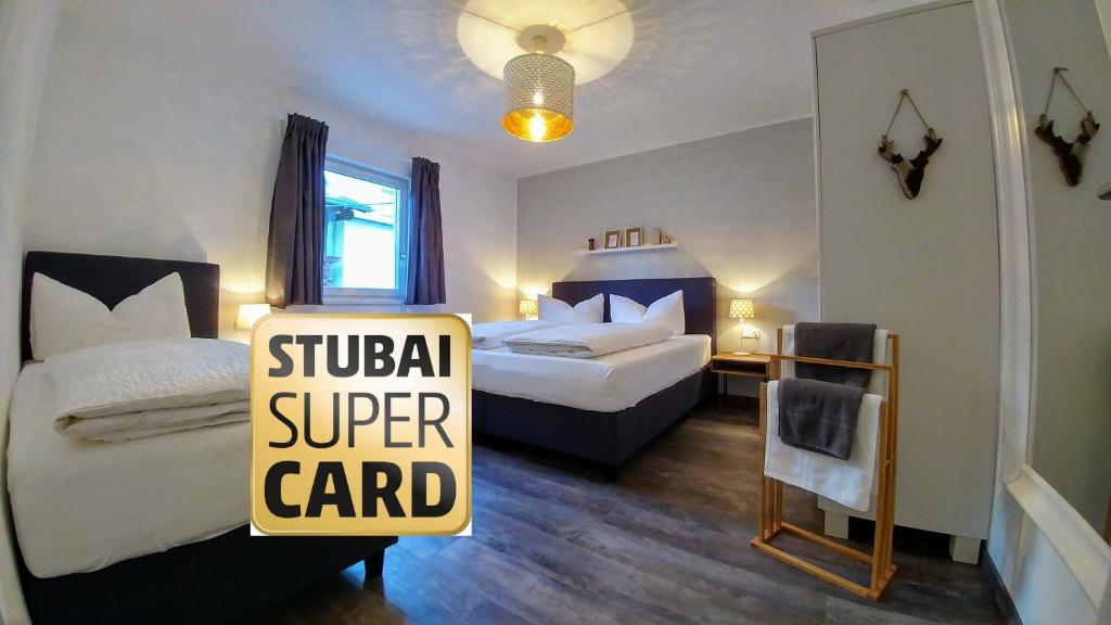a hotel room with two beds and a sign for a super card at no.dreizehn in Neustift im Stubaital