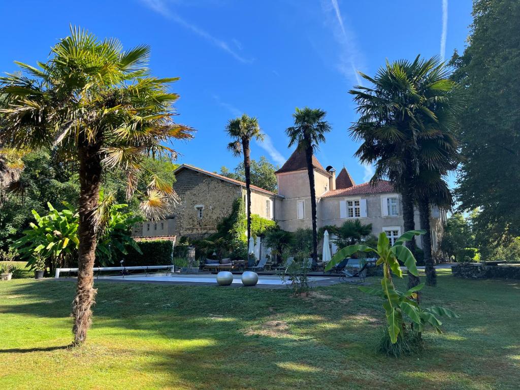 a house with palm trees in front of it at Chateau Saint Martin B&B in Pouillon
