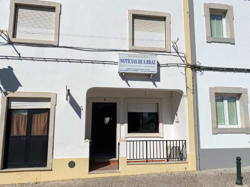 ein weißes Gebäude mit einem Schild auf der Vorderseite in der Unterkunft casa Sao bras Alportel Miguel in São Brás de Alportel